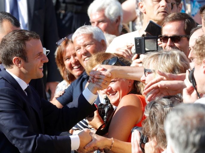 French President Emmanuel Macron shakes hands with supporters as he leaves city hall, after casting his ballot in the second round of the parliamentary election, in Le Touquet, France June 18, 2017. REUTERS/Philippe Wojazer