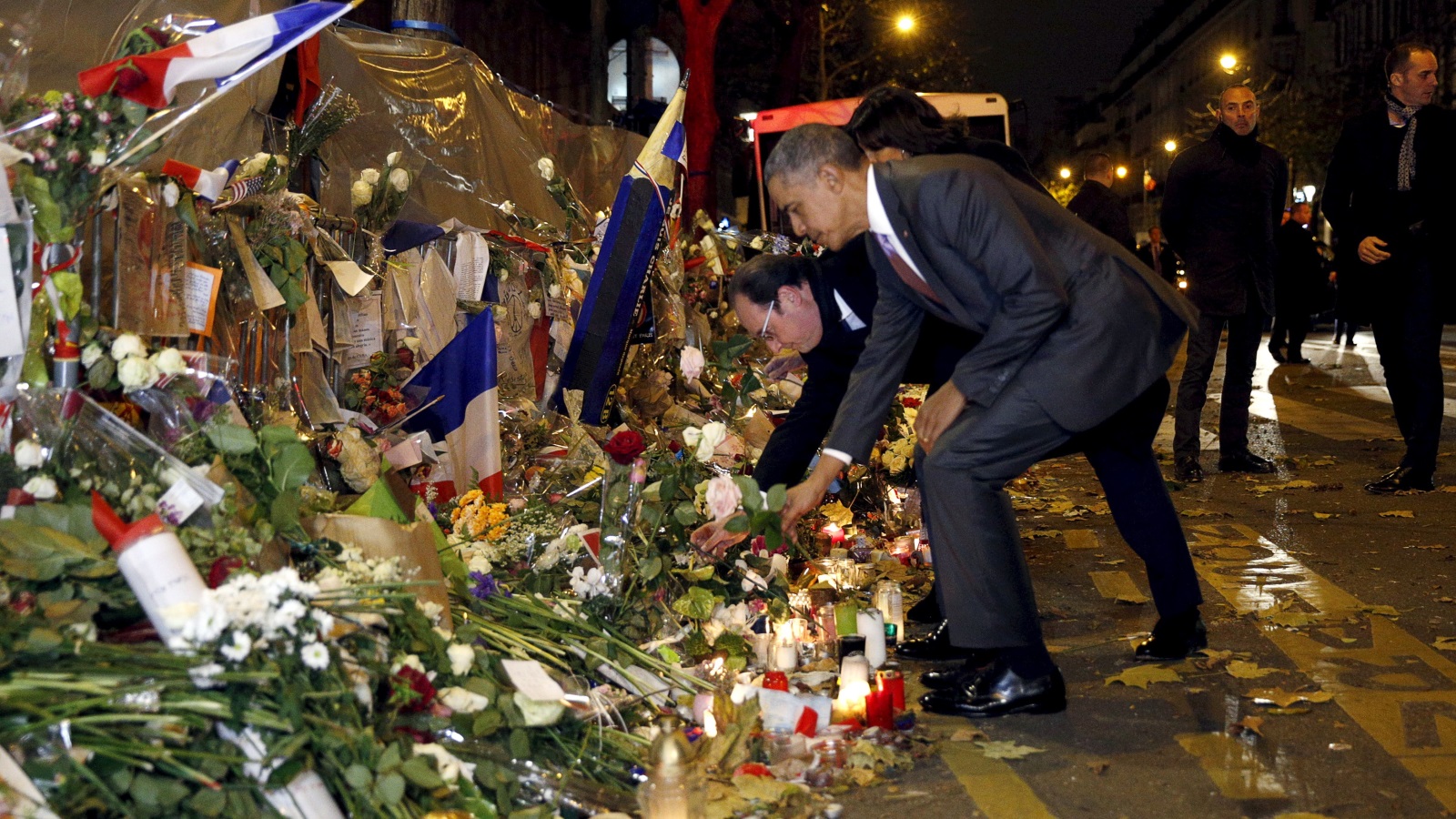  الرئيس الفرنسي السابق هولاند والرئيس الأميركي السابق أوباما يضعان الزهور لضحايا هجمات باريس في نوفمبر 2015 (رويترز)