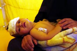 A Yemeni woman holds her cholera-infected child receiving treatment amid an acute cholera outbreak, inside a makeshift tent at a hospital in Sana’a