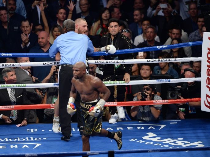 Aug 26, 2017; Las Vegas, NV, USA; Floyd Mayweather Jr. (black trunks) celebrates after knocking out Conor McGregor (white trunks) during their boxing match at T-Mobile Arena. Mayweather won via 10th round TKO. Mandatory Credit: Joe Camporeale-USA TODAY Sports