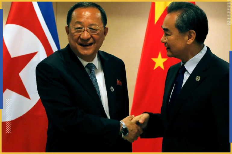 وزير الخارجية الصيني وانغ يي مع وزير خارجية كوريا الشمالية ري يونغ (رويترز)