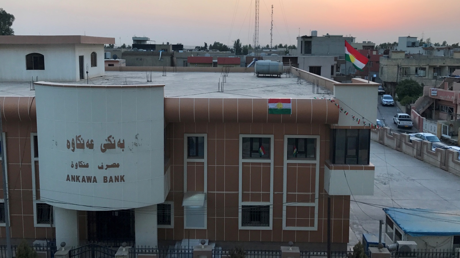 العلم الكردي مرفوع فوق مصرف عنكاوة في أربيل (رويترز)