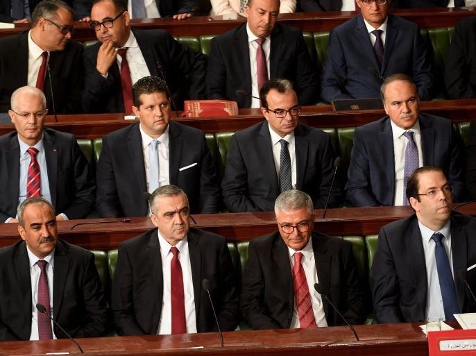 Tunisian Prime Minister Youssef Chahed (bottom R) sits next to nominated defence minister, Abdelkrim Zbidi (bottom 2nd R), nominated interior minister, Lotfi Brahem (bottom 2nd L), nominated finance minister Ridha Chalghoum (bottom L), nominated education minister Hatem Ben Salem (R, second raw) and nominated health minister Slim Chaker (2nd from R, second raw) during a parliamentary session ahead of a vote of confidence in his reshuffled government, on September 11, 2017, in Tunis.Chahed on September 6, 2017 announced a major cabinet reshuffle, replacing the key ministers of interior and defence. Three of 11 new faces in the 27-member government served as ministers under the rule of president Zine El Abidine Ben Ali, who was overthrown in Tunisia's 2011 revolution. / AFP PHOTO / FETHI BELAID (Photo credit should read FETHI BELAID/AFP/Getty Images)