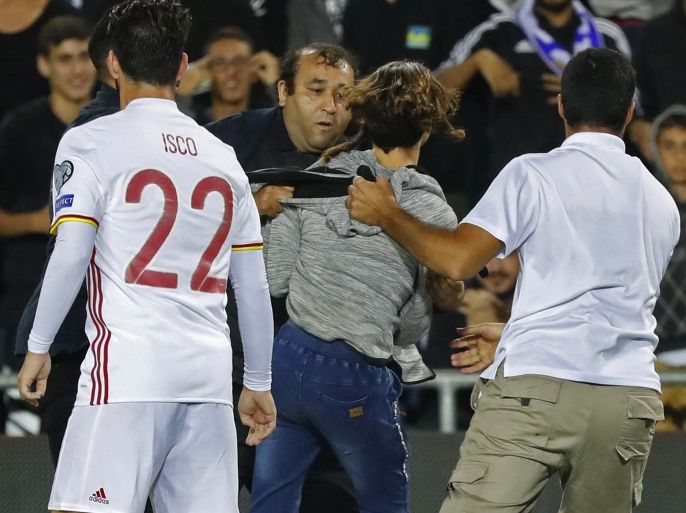 A pitch invader is detained by securiy during the Russia 2018 FIFA World Cup European Group G qualifying football match between Israel and Spain at Teddy Stadium in Jerusalem on October 9, 2017.Israeli police denied local media reports that the pitch invader who ran towards Spanish attacker Isco during a World Cup qualifier was carrying a knife. The Israeli news website Ynet cited security officials in the stadium as saying six fans entered the field at the end of the game, with one of them carrying a small knife in his sock. / AFP PHOTO / Jack GUEZ AND JACK GUEZ (Photo credit should read JACK GUEZ/AFP/Getty Images)