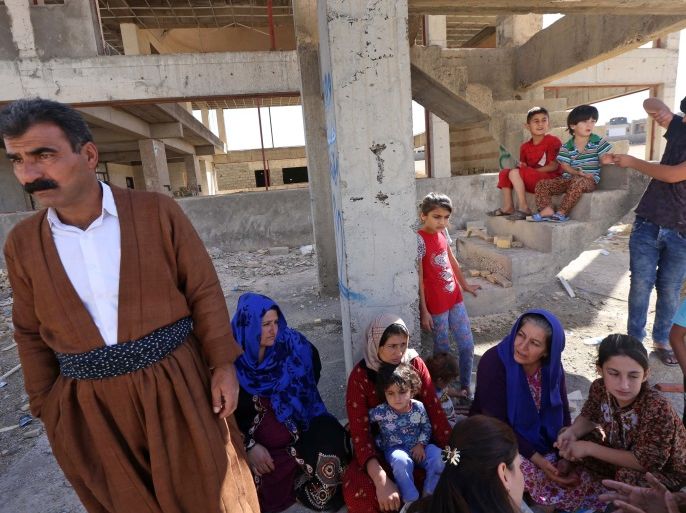 Displaced Iraqi Kurdish people fleeing violence in the northern Kirkuk province sit an unfinished housing project where they are taking shelter in Arbil, the capital of the autonomous Kurdish region of northern Iraq, on October 19, 2017. / AFP PHOTO / SAFIN HAMED (Photo credit should read SAFIN HAMED/AFP/Getty Images)