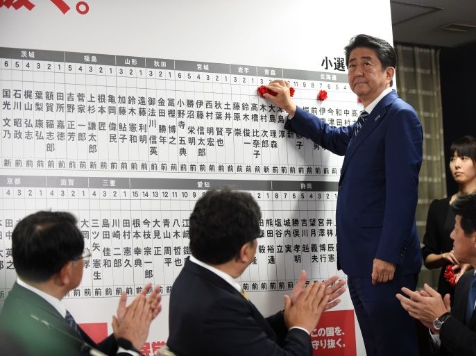 Japan's Prime Minister and ruling Liberal Democratic Party leader Shinzo Abe puts rosettes by successful general election candidates' names on a board at the party headquarters in Tokyo on October 22, 2017.Abe swept to a resounding victory in a snap election on October 22, winning a mandate to harden his already hawkish stance on North Korea and re-energise the world's number-three economy. / AFP PHOTO / Toru YAMANAKA (Photo credit should read TORU YAMANAKA/AFP/Getty Images)