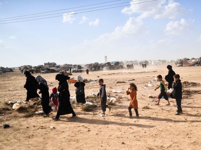 Syrians displaced from the city of Deir Ezzor walk on the outskirts of Raqa on October 2, 2017. Syrian fighters backed by US special forces are battling to clear the last remaining Islamic State group jihadists holed up in their crumbling stronghold of Raqa. / AFP PHOTO / BULENT KILIC (Photo credit should read BULENT KILIC/AFP/Getty Images)