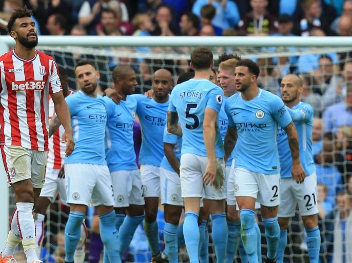 Stoke City's German midfielder Eric Maxim Choupo-Moting (L) reacts as Manchester City players celebrate their sixth goal during the English Premier League football match between Manchester City and Stoke City at the Etihad Stadium in Manchester, north west England, on October 14, 2017. / AFP PHOTO / Lindsey PARNABY / RESTRICTED TO EDITORIAL USE. No use with unauthorized audio, video, data, fixture lists, club/league logos or 'live' services. Online in-match use limited to 75 images, no video emulation. No use in betting, games or single club/league/player publications. / (Photo credit should read LINDSEY PARNABY/AFP/Getty Images)