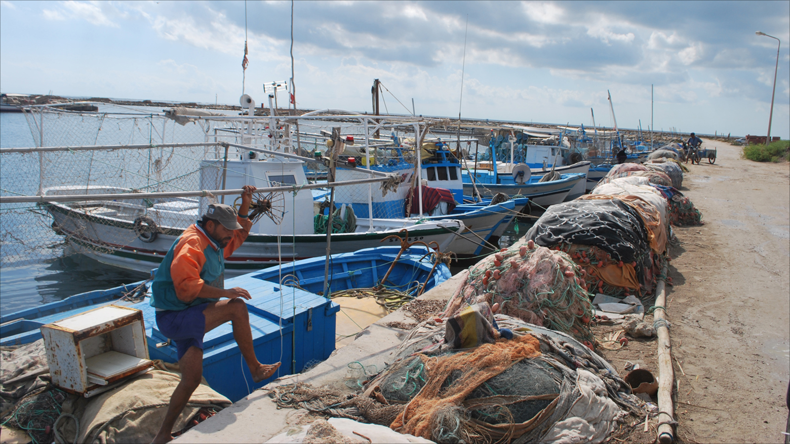 جانب من شباك الصيادين الممزقة بسبب عقارب البحر في ميناء 