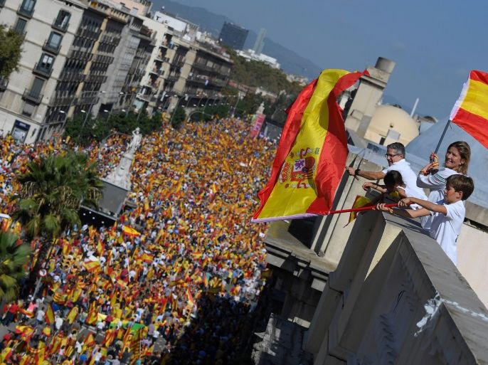 Protesters wave Spanish flags from a balcony during a demonstration called by 'Societat Civil Catalana' (Catalan Civil Society) to support the unity of Spain on October 8, 2017 in Barcelona.Spain braced for more protests despite tentative signs that the sides may be seeking to defuse the crisis after Madrid offered a first apology to Catalans injured by police during their outlawed independence vote. / AFP PHOTO / LLUIS GENE (Photo credit should read LLUIS GENE/AFP/Getty Images)