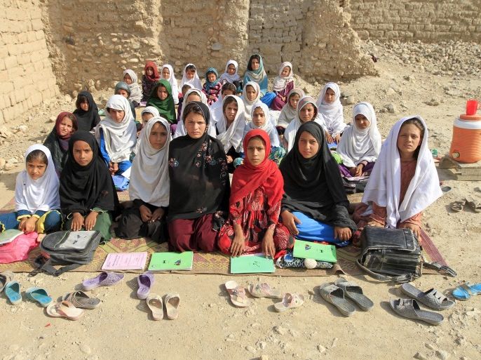 Teacher Mahajera Armani and her class of girls pose for a picture at their study open area, founded by Bangladesh Rural Advancement Committee (BRAC), outside Jalalabad city, Afghanistan September 19, 2015. Nearly three years after Taliban gunmen shot Pakistani schoolgirl Malala Yousafzai, the teenage activist last week urged world leaders gathered in New York to help millions more children go to school. World Teachers' Day falls on 5 October, a Unesco initiative highlighting the work of educators struggling to teach children amid intimidation in Pakistan, conflict in Syria or poverty in Vietnam. Even so, there have been some improvements: the number of children not attending primary school has plummeted to an estimated 57 million worldwide in 2015, the U.N. says, down from 100 million 15 years ago. Reuters photographers have documented learning around the world, from well-resourced schools to pupils crammed into corridors in the Philippines, on boats in Brazil or in crowded classrooms in Burundi. REUTERS/Parwiz PICTURE 19 OF 47 FOR WIDER IMAGE STORY