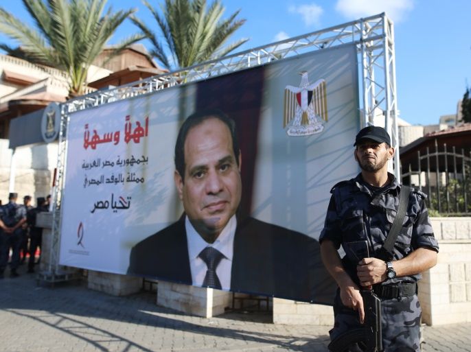 A Palestinian security guard loyal to Hamas stands next to a billboard bearing the portrait of Egyptian President Abdel Fattah al-Sisi near the Palestinian government headquarters in Gaza City on October 3, 2017. / AFP PHOTO / MOHAMMED ABED (Photo credit should read MOHAMMED ABED/AFP/Getty Images)