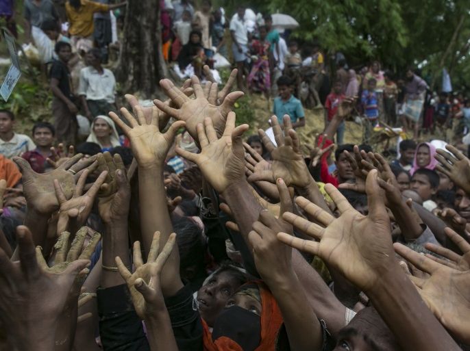 COX'S BAZAR, BANGLADESH - SEPTEMBER 18: Hands of refugees stretch out as they scramble for donations in the Balukhali camp on September 18, 2017 in Cox's Bazar, Bangladesh. Nearly 400,000 Rohingya refugees have fled into Bangladesh since late August during the outbreak of violence in the Rakhine state as recent satellite images released by Amnesty International provided evidence that security forces were trying to push the minority Muslim group out of the country. My