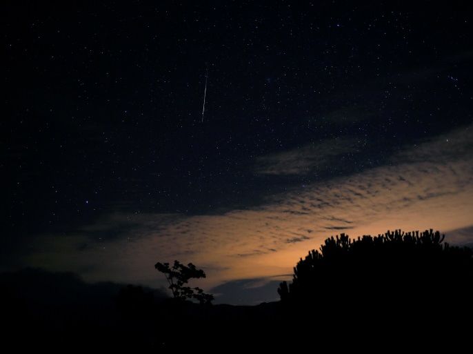 A meteor streaks past stars in the night sky over a cloud during the annual Orionid meteor shower at the Sierra de las Nieves nature park and biosphere reserve in Parauta, near Malaga, Spain October 22, 2017. REUTERS/Jon Nazca