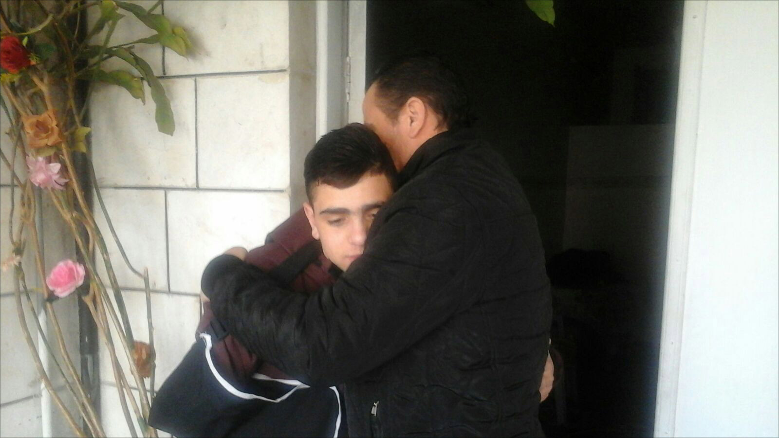الطفل فوزي الجنيدي في حضن والده بعد الإفراج عنه من سجون الاحتلال الإسرائيلي (الجزيرة)