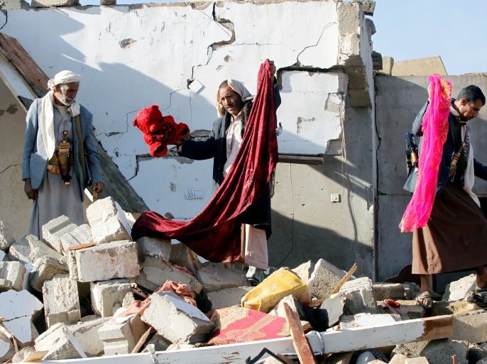 People show clothes of victims at the site of a Saudi-led air strike which struck a house where mourners had gathered for a funeral north of Yemen's capital Sanaa, February 16, 2017. REUTERS/Mohamed al-Sayaghi