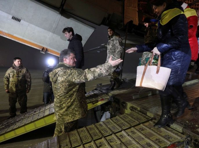 Ukrainian President Petro Poroshenko helps a woman to get off a plane during a ceremony to welcome prisoners of war (POWs), released after the exchange with pro-Russian separatists, at Boryspil International Airport outside Kiev, Ukraine December 28, 2017. Mikhail Palinchak/Ukrainian Presidential Press Service/Handout via REUTERS ATTENTION EDITORS - THIS IMAGE WAS PROVIDED BY A THIRD PARTY.