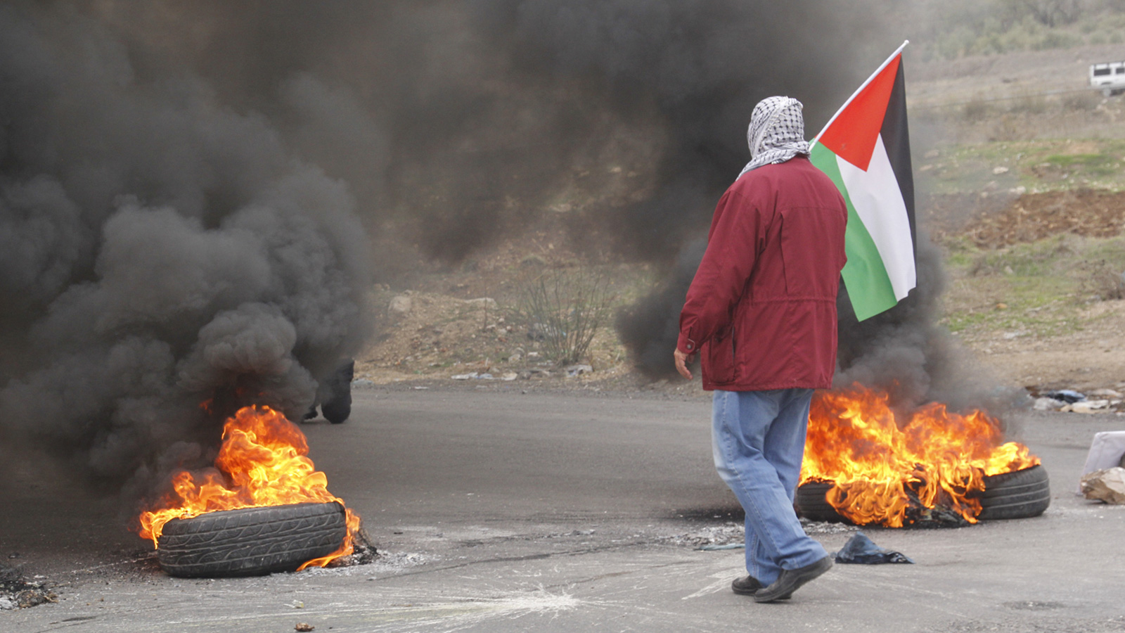 علم فلسطين مرفوع خلال المواجهات عند حاجز حوارة جنوب نابلس (الجزيرة نت)