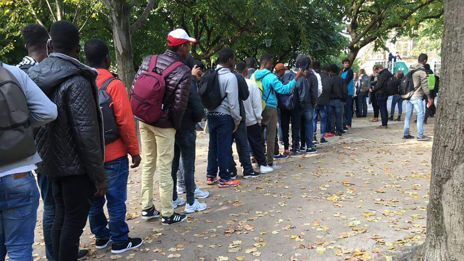 طالبو لجوء ينتظرون تقديم ملفاتهم أمام مركز للمهاجرين في باريس (الجزيرة نت)