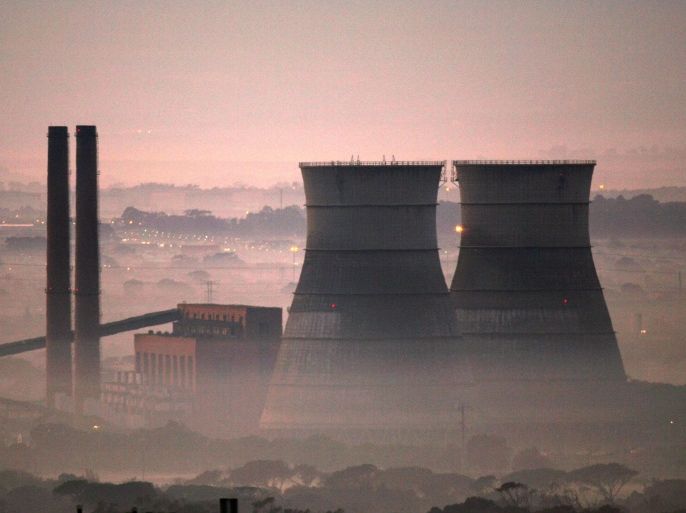 Early morning smog shrouds cooling towers of a power plant in Cape Town, South Africa, June 8, 2006. REUTERS/Mike Hutchings/File Photo