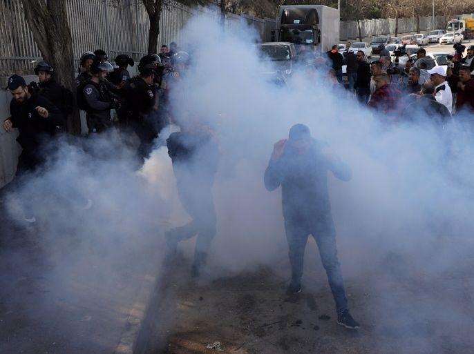 Palestinians react at tear gas that was shot by Israeli forces after Friday prayer on a street outside the East Jerusalem neighbourhood of Issawiya, February 2, 2018. REUTERS/Ammar Awad