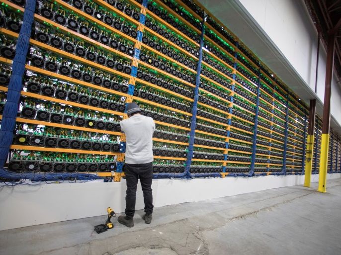 A worker checks the fans on miners, at the cryptocurrency farming operation, Bitfarms, in Farnham, Quebec, Canada, February 2, 2018. Picture taken February 2, 2018. REUTERS/Christinne Muschi