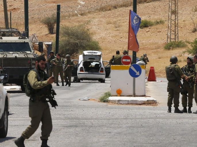 Israeli soldiers inspect the area following a shooting attack near the West Bank city of Jericho June 26, 2015. Israeli soldiers shot and killed a Palestinian gunman in the occupied West Bank on Friday after he opened fire on them at a checkpoint, the Israeli military said. REUTERS/Ammar Awad