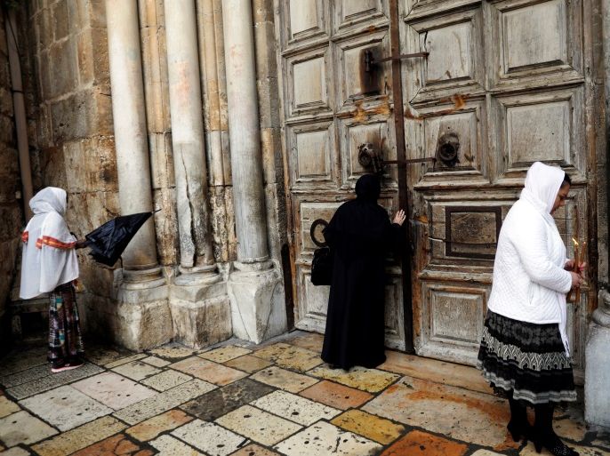 Worshippers stand in front of the closed doors of the Church of the Holy Sepulchre in Jerusalem's Old City February 26, 2018. REUTERS/Ronen Zvulun