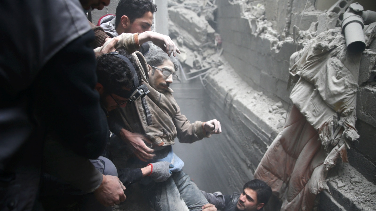 ‪مدنيون يحاولون إنقاذ الضحايا بعد قصف جوي على أحياء الغوطة‬ (رويترز)