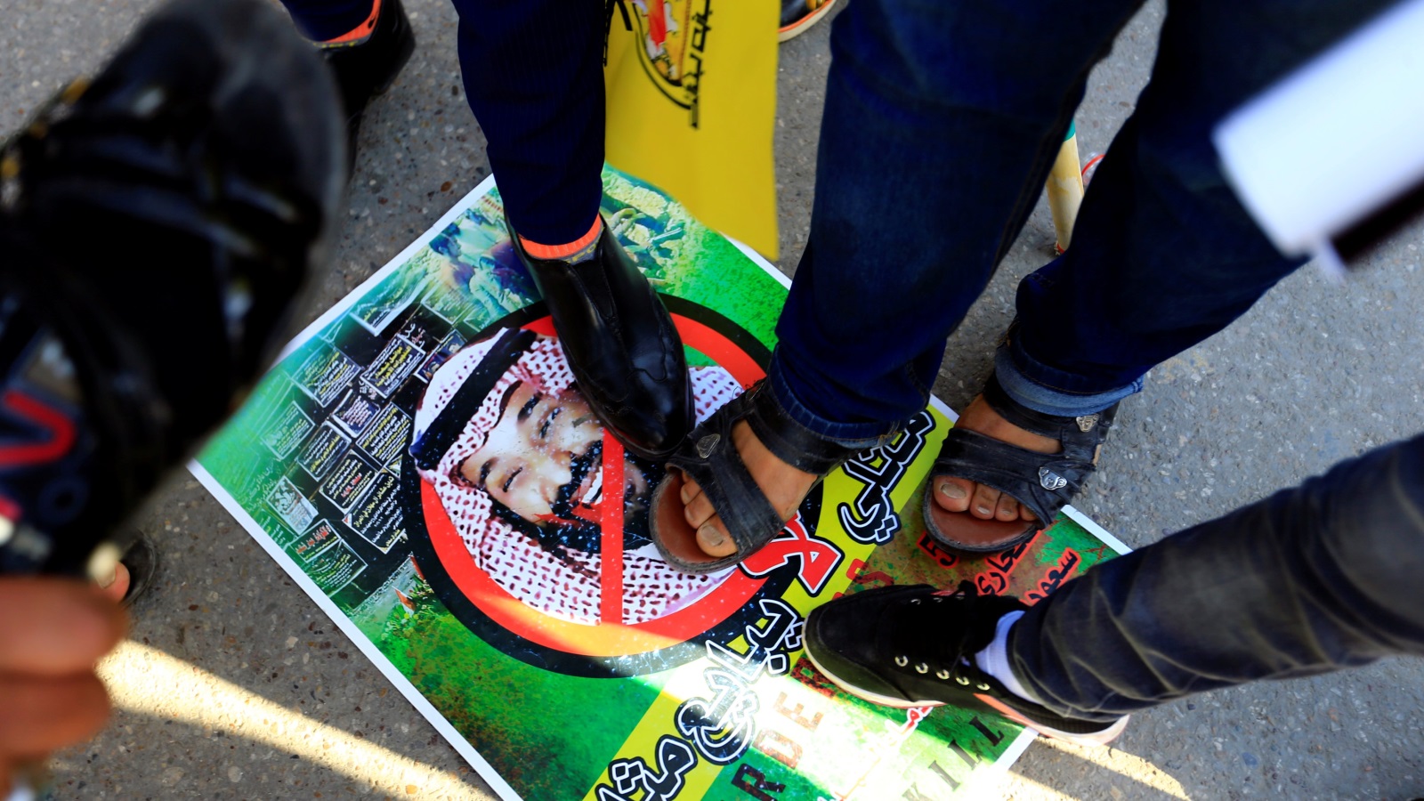 متظاهرون داسوا على صورة ابن سلمان بالأقدام (رويترز)