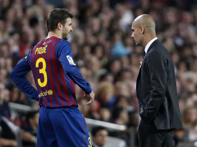 Barcelona's player Gerard Pique (L) talks with Barcelona's coach Pep Guardiola after leaving the pitch injured during their Spanish first division soccer match against Racing de Santander at Nou Camp stadium in Barcelona October 15, 2011. REUTERS/Gustau Nacarino (SPAIN - Tags: SPORT SOCCER)