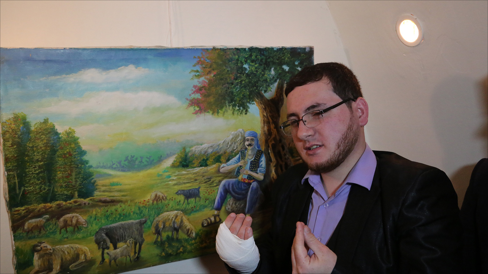 المقيد يشرح بلغة الإشارة إحدى لوحاته (الجزيرة)