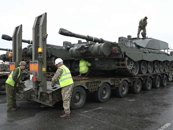PALDISKI, ESTONIA - MARCH 22: A crew secures a British Army Challenger 2 tank of the 5th Battalion The Rifles to a truck trailer after the tank and other heavy vehicles arrived by ship on March 22, 2017 at Paldiski, Estonia. British heavy tanks, light tanks, mobile artillery and other equipment unloaded at Paldiski today as part of a deployment by approximately 800 British combat troops taking part in the multinational NATO Enhanced Forward Presence battalion. NATO mem