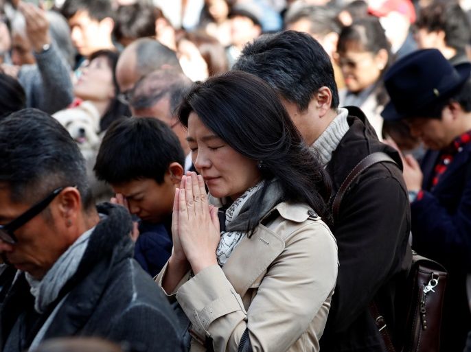 People attend a moment of silence at 2:46 p.m. (0546 GMT), the time when the magnitude 9.0 earthquake struck off Japan's coast in 2011, at a holiday promenade at Ginza shopping district in Tokyo, Japan, March 11, 2018, to mark the seven-year anniversary of the earthquake and tsunami that killed thousands and set off a nuclear crisis. REUTERS/Issei Kato