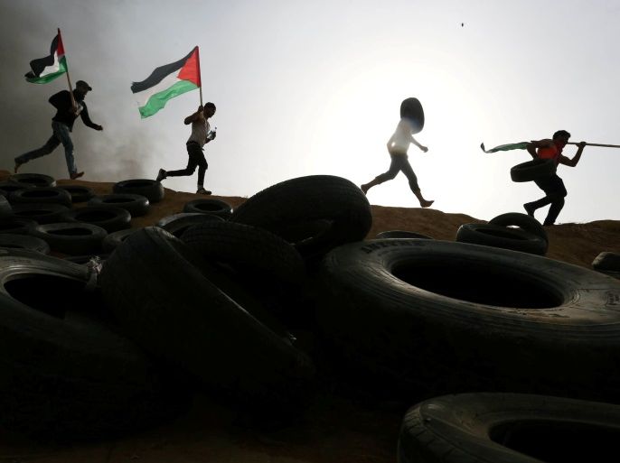 Palestinian protesters run during clashes with Israeli troops at Israel-Gaza border, in the southern Gaza Strip April 5, 2018. REUTERS/Ibraheem Abu Mustafa TPX IMAGES OF THE DAY