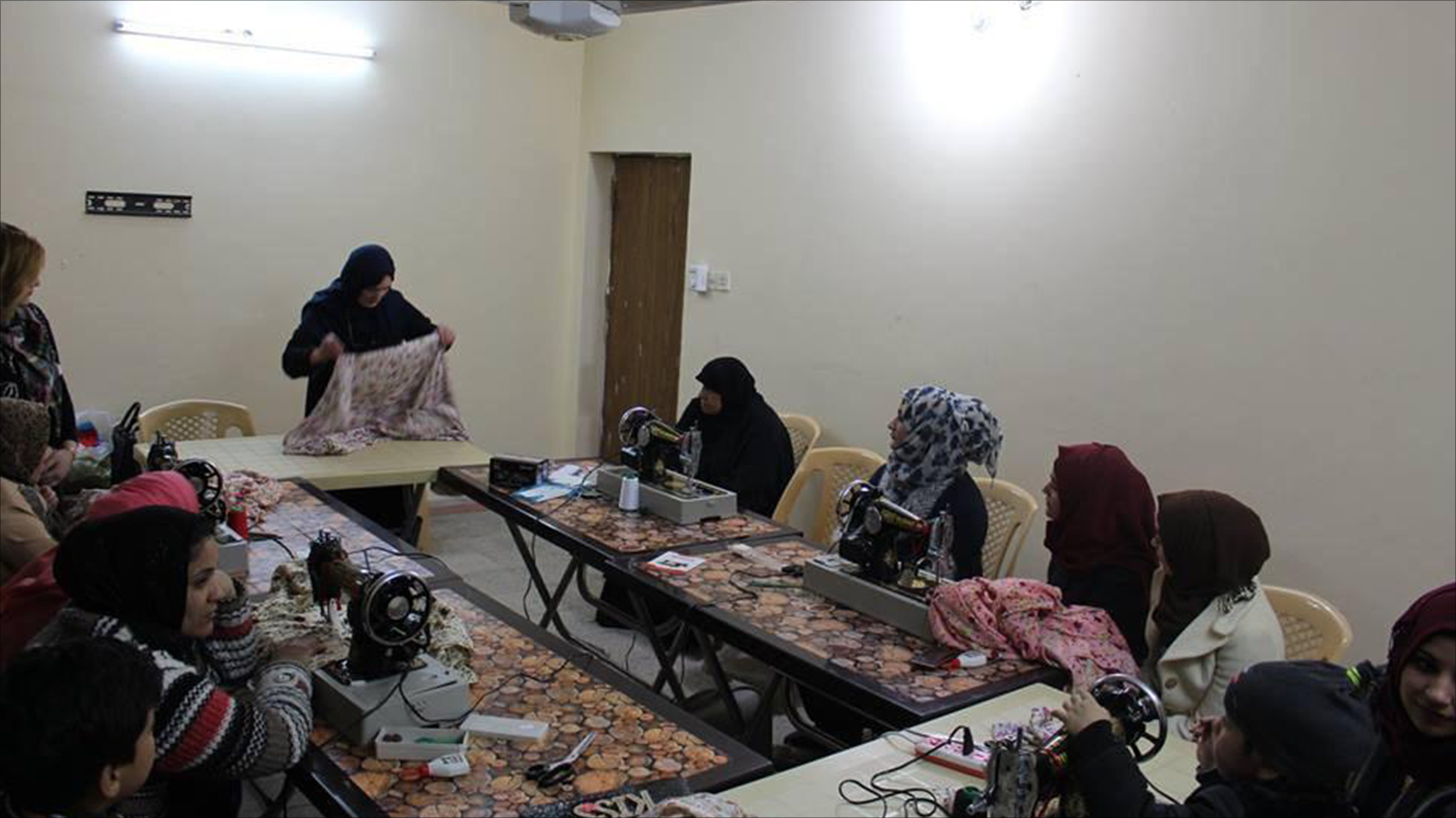 ‪دورة لتعليم الخياطة أقامتها مرشحة في منطقة شعبية ببغداد‬ (الجزيرة)