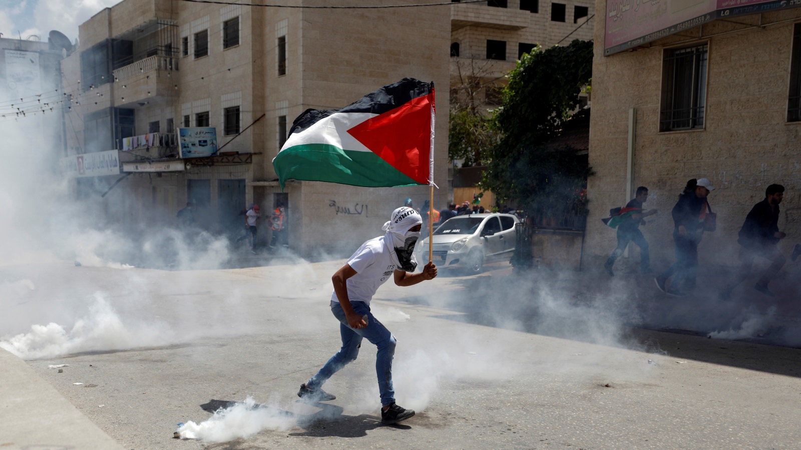 متظاهر فلسطيني عند حاجز قلنديا قرب رام الله احتجاجا على نقل السفارة (رويترز)