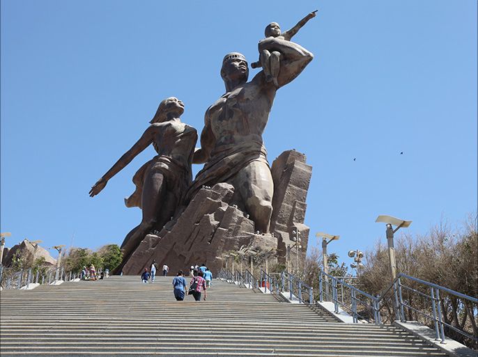 سياح غربيون يزورون تمثال النهضة في داكار