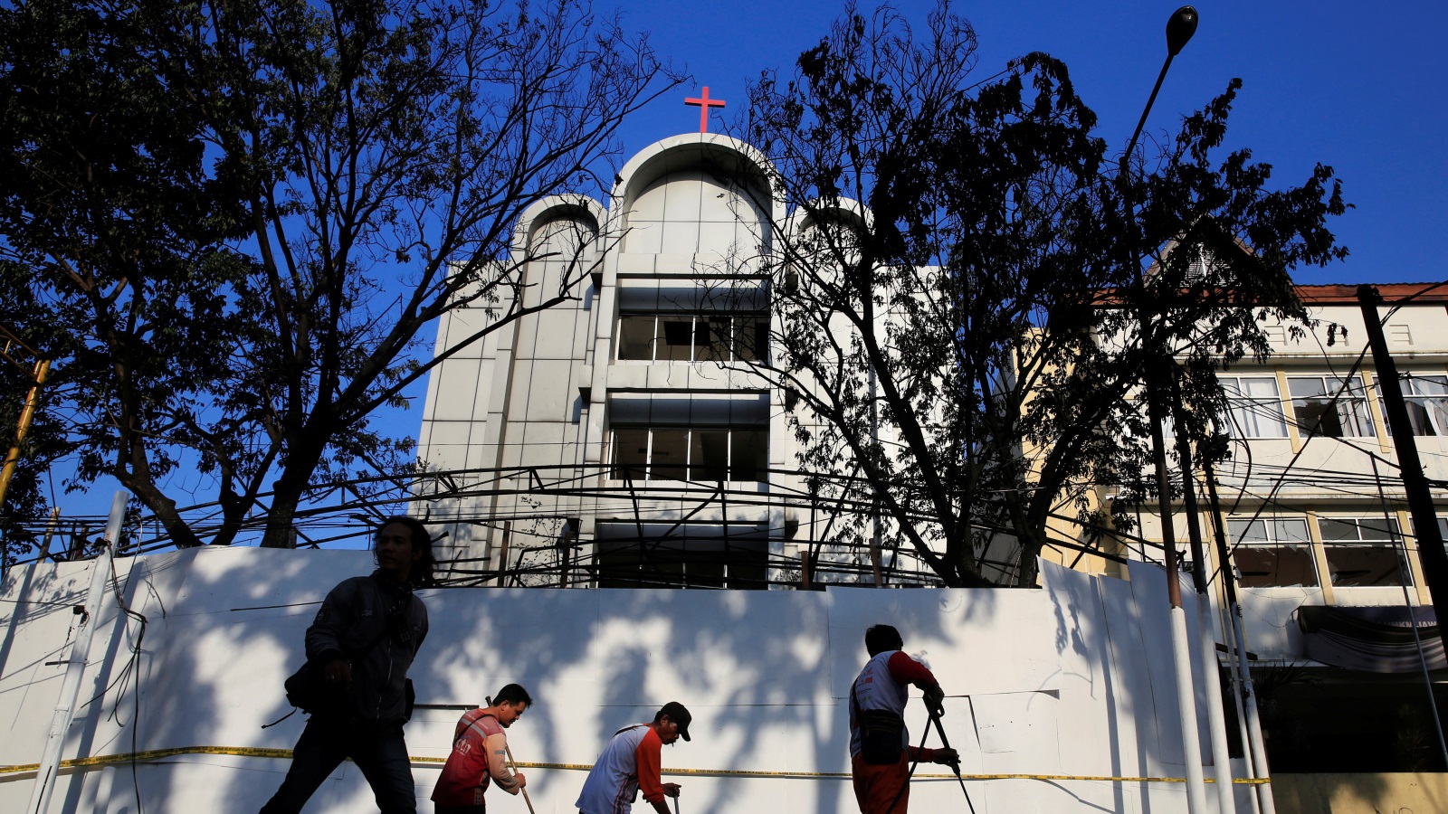  عمال النظافة يزيلون آثار هجمات أمس الانتحارية على الكنيسة(رويترز)