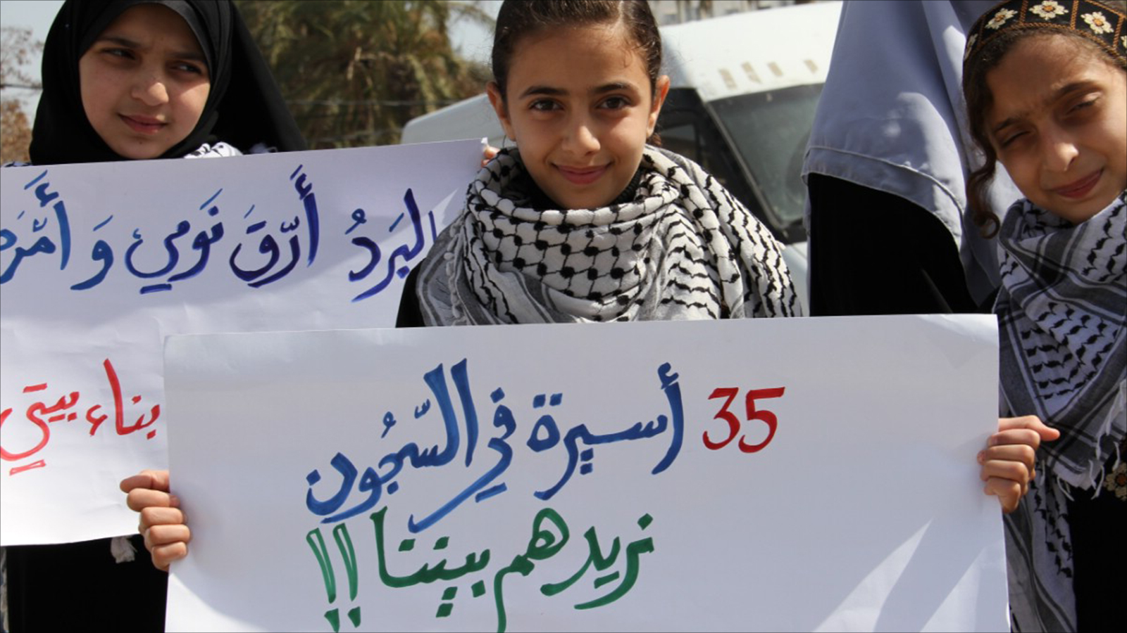 ‪طفلة فلسطينية تحمل لافتة تذّكر بوجود 35 أسيرة‬ (الجزيرة)
