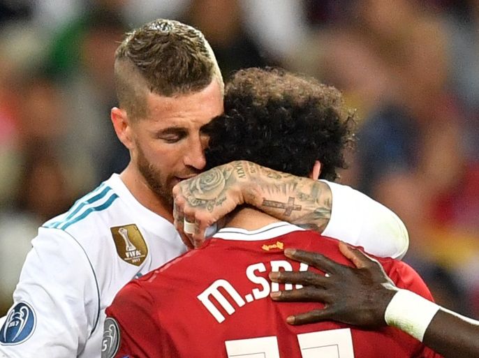 epa06765574 Sergio Ramos of Real Madrid (L) hugs Mohamed Salah of Liverpool (R) as he is let off the pitch for a medical check during the UEFA Champions League final between Real Madrid and Liverpool FC at the NSC Olimpiyskiy stadium in Kiev, Ukraine, 26 May 2018. EPA-EFE/GEORGI LICOVSKI