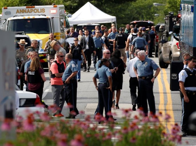 Law enforcement officials survey the scene after a gunman fired through a glass door at the Capital Gazette newspaper and sprayed the newsroom with gunfire, killing at least five people and injuring several others in Annapolis, Maryland, U.S., June 28, 2018. REUTERS/Joshua Roberts