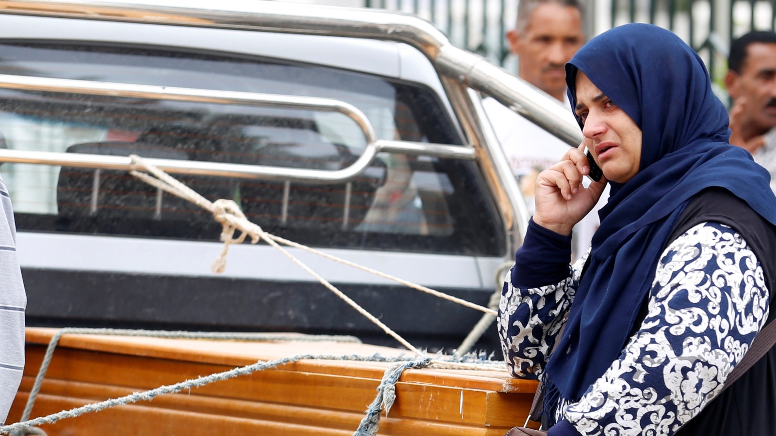 ‪(رويترز)‬ سيدة تونسية تقف إلى جانب نعش أحد أقاربها الذين لقوا حتفهم في غرق المركب