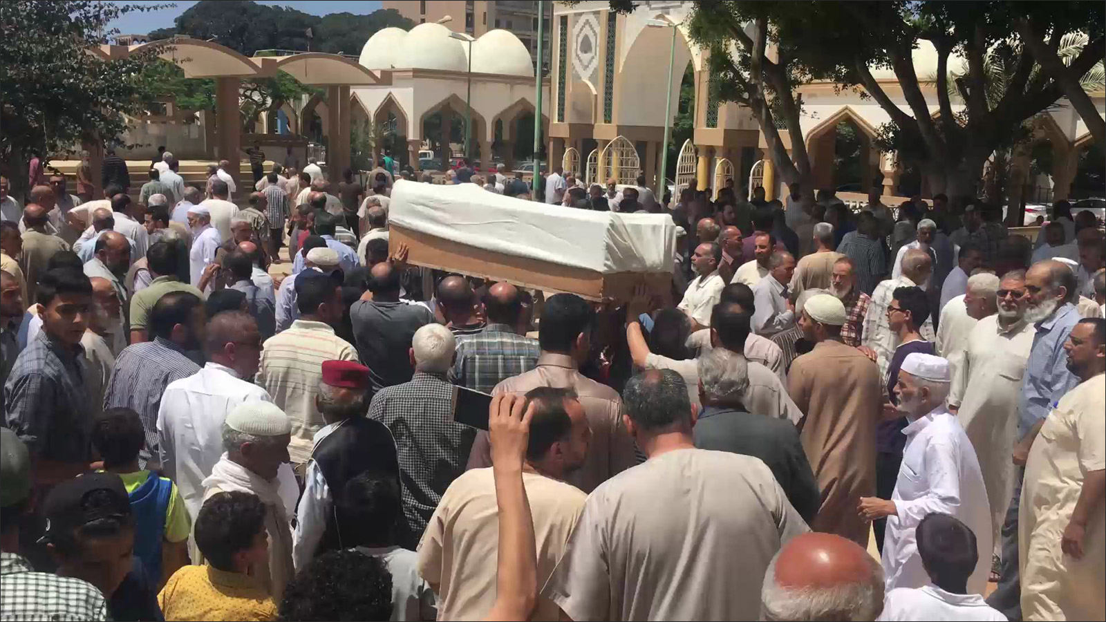 ‪سكان درنة أثناء تشييع جثمان مدني قتل جراء القصف قبل نحو أسبوعين‬ (الجزيرة)