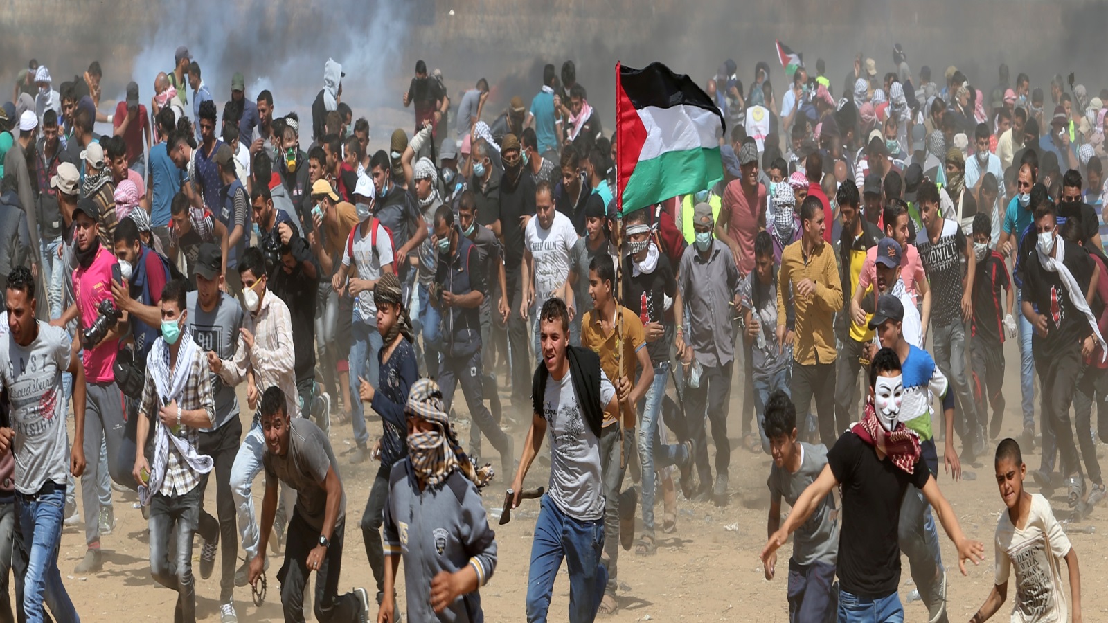احتجاج مئات الفلسطينيين في غزة خلال فعالية سابقة لمسيرة العودة قرب السياج الحدودي (رويترز) 