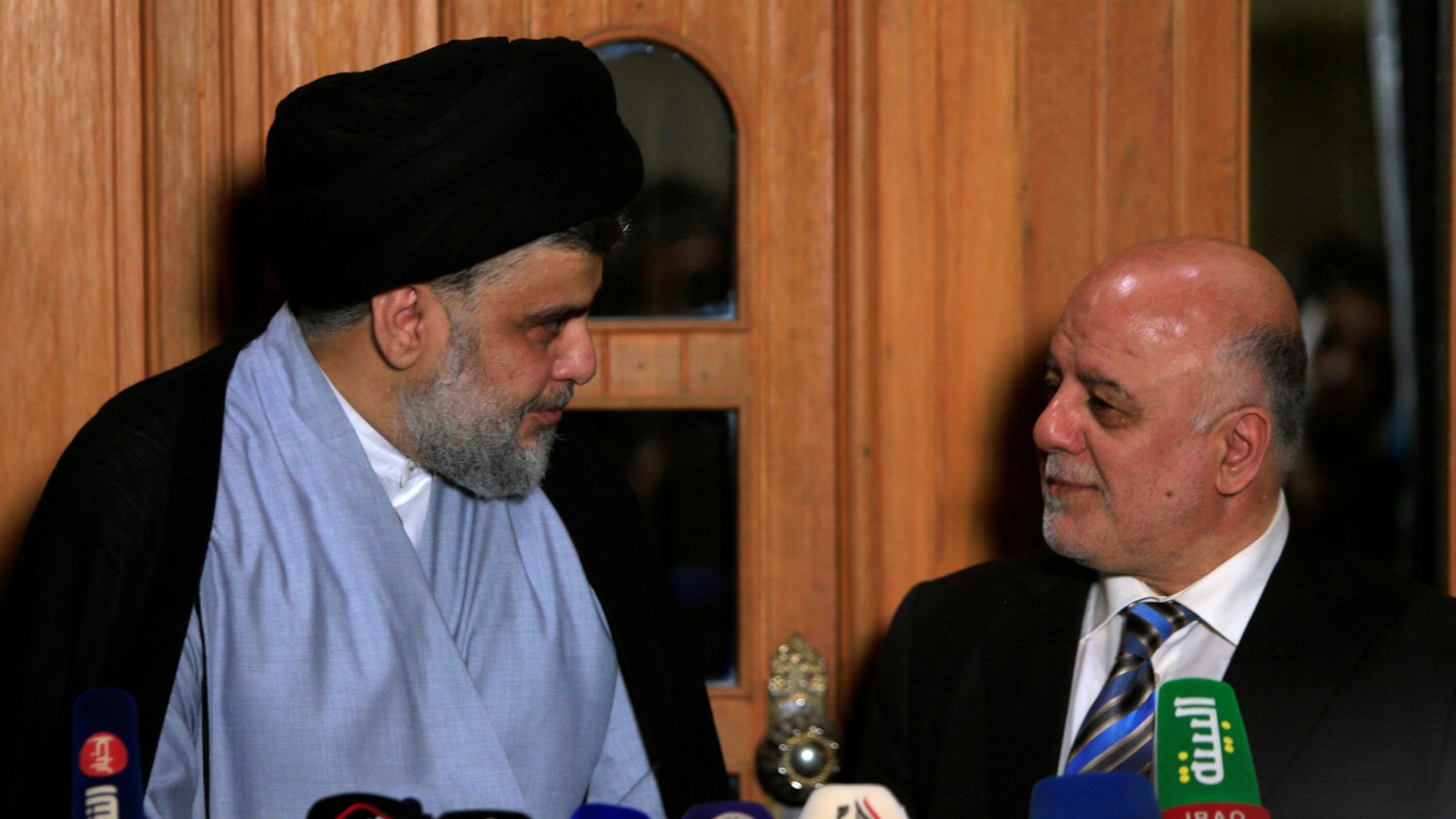 رئيس الحكومة العراقية حيدر العبادي (يمين) مع مقتدى الصدر خلال مشاورات تشكيل الكتل السياسية (رويترز)