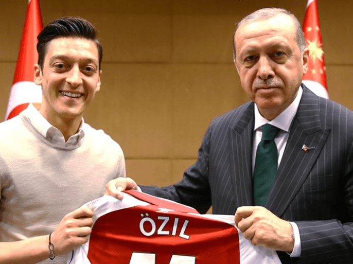LONDON, UNITED KINGDOM - MAY 13: Turkish-German football player Mesut Ozil who plays for Arsenal (L) presents a jersey to Turkish President Recep Tayyip Erdogan before their meeting in London, United Kingdom on May 13, 2018.