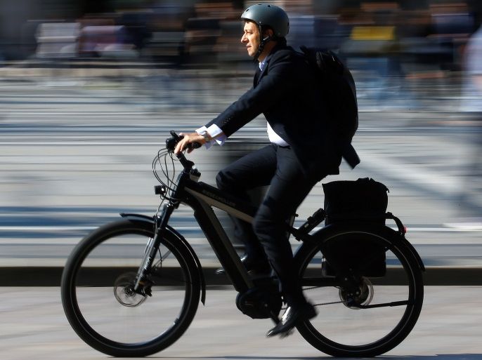 A man rides an electric bicycle, also known as an e-bike, in downtown Milan, Italy, May 18, 2018. REUTERS/Stefano Rellandini