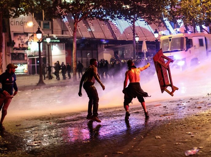 PARIS, FRANCE - JULY 15: Water canon is used as French football fans clash with police following celebrations on the Champs-Elysees after France's victory against Croatia in the World Cup Final on July 15, 2018 in Paris, France. France beat Croatia 4-2 in the World Cup Final played at Moscow's Luzhniki Stadium today. (Photo by Jack Taylor/Getty Images)
