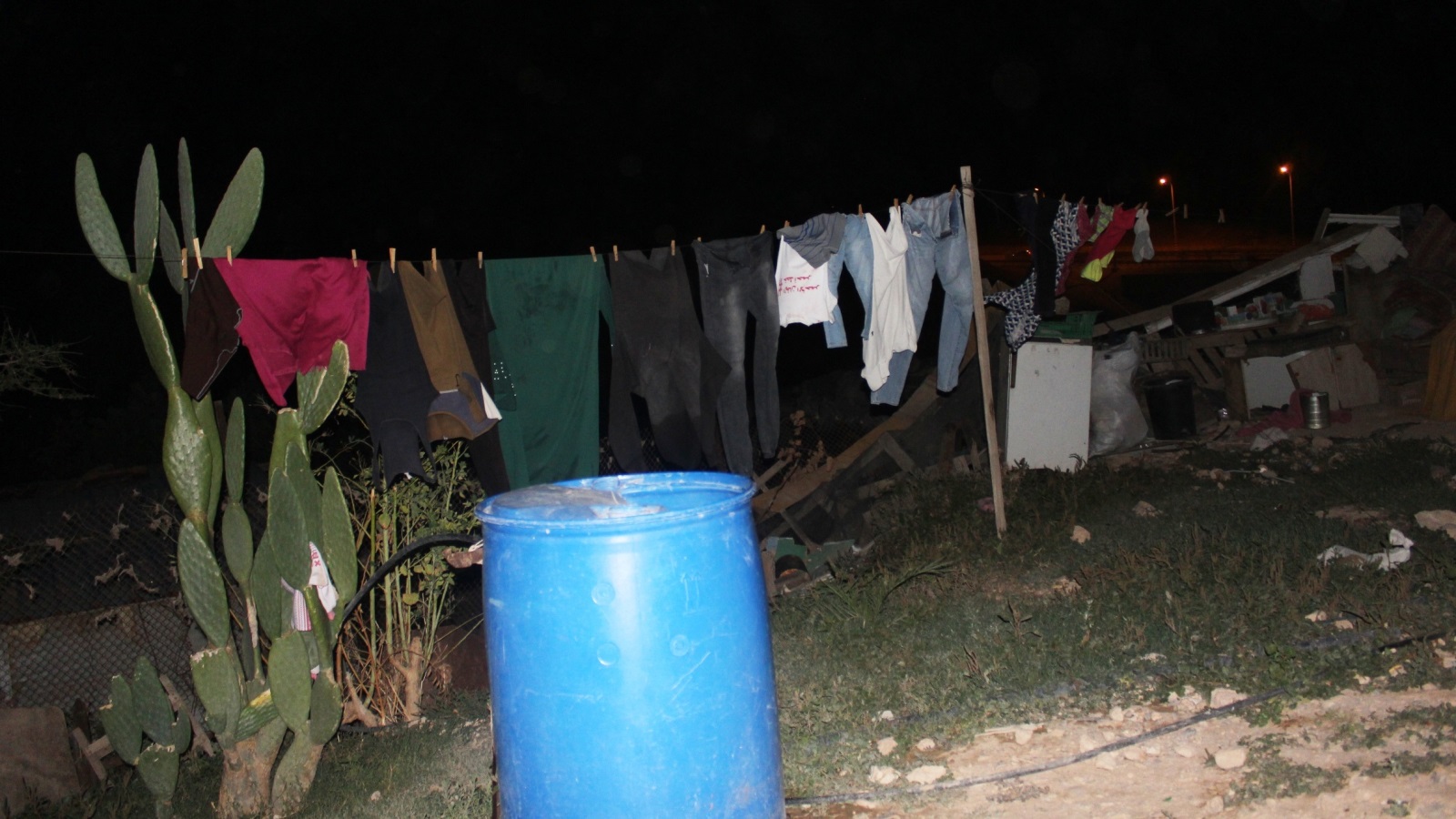 عادت نساء الخان الأحمر لغسل الملابس في الأواني البلاستيكية بعد حرمانهن من الكهرباء (الجزيرة)